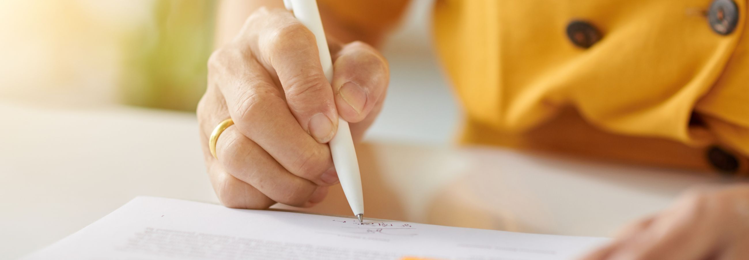 Eine Person füllt ein Formular mit einem Stift aus