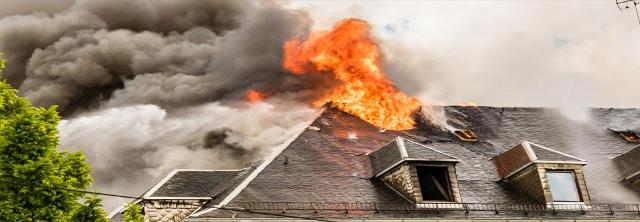 Aus dem Dachstuhl eines Hauses schlagen Flammen