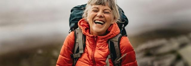 Lachende Seniorin beim Wandern