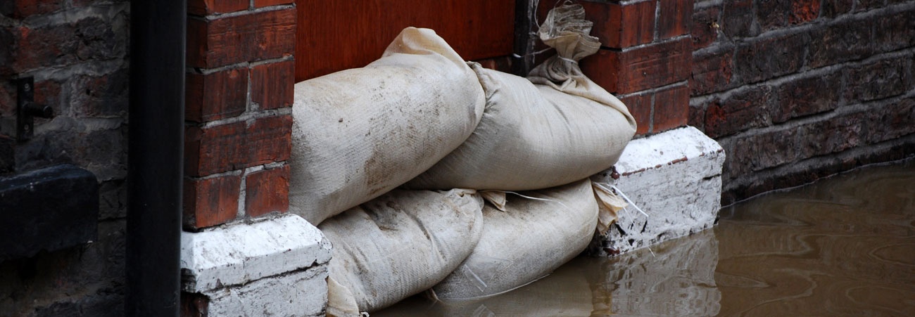 Gestapelte Sandsäcke schützen eine Tür bei Hochwasser