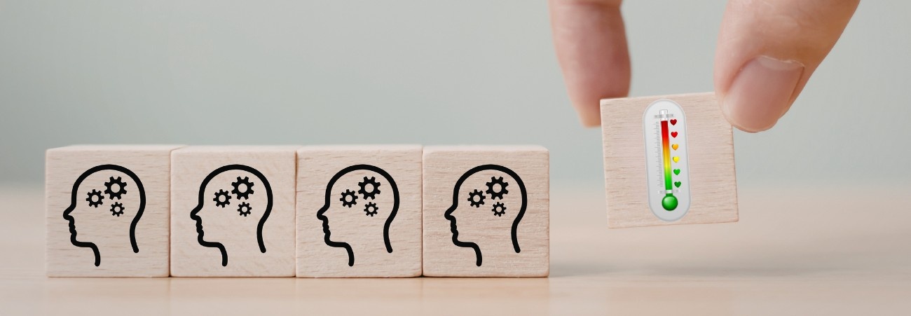 Holzklötze mit stilisiertem Kopf und Zahnrädern, weiterer Klotz mit einer farbigen Temperaturanzeige