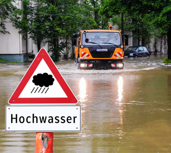 Warnschild Hochwasser vor überfluteter Straße