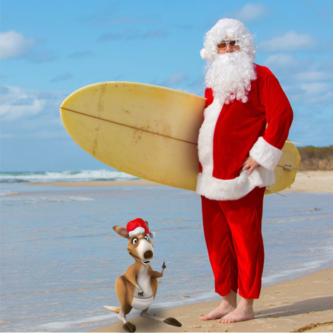 Weihnachtsmann mit Surfbrett am Strand