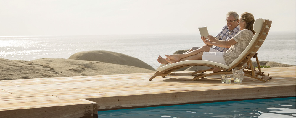 Älteres Paar auf Sonnenliegen am Meer