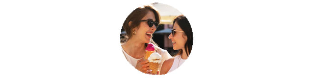 Zwei Frauen essen lachend ein Eis